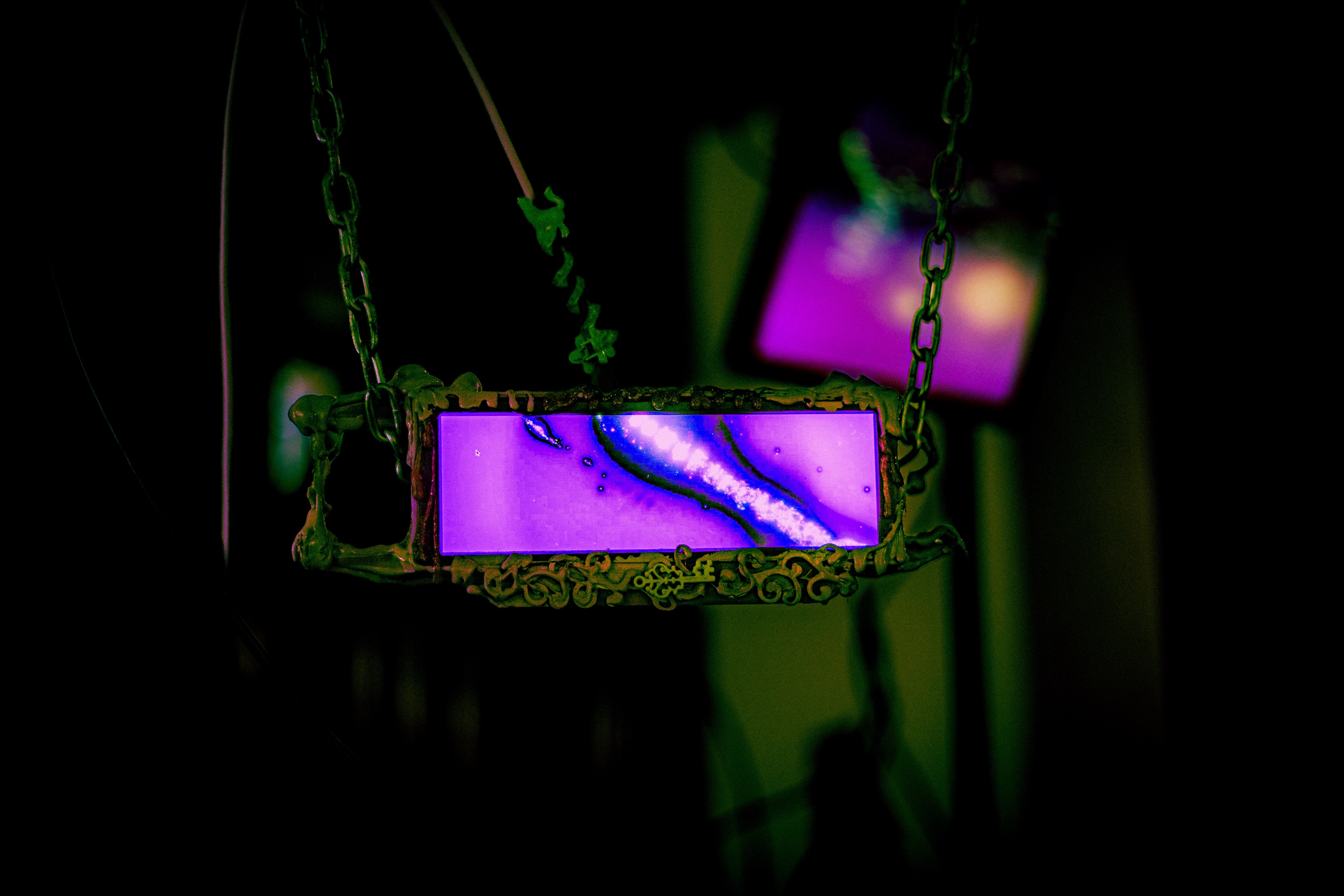 the same wide slime-framed panel, greener now, showing a purple wash with a bright white and blue seam of light pouring across it, a blurred purple screen floating behind