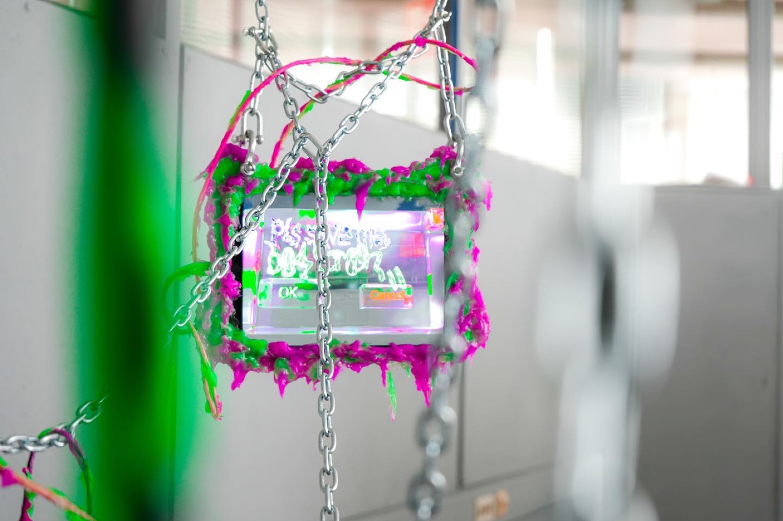 a small screen bordered in dripping magenta and green cyberslime and wrapped in steel chain, showing a glitched password dialog with ok and cancel buttons glowing on it.